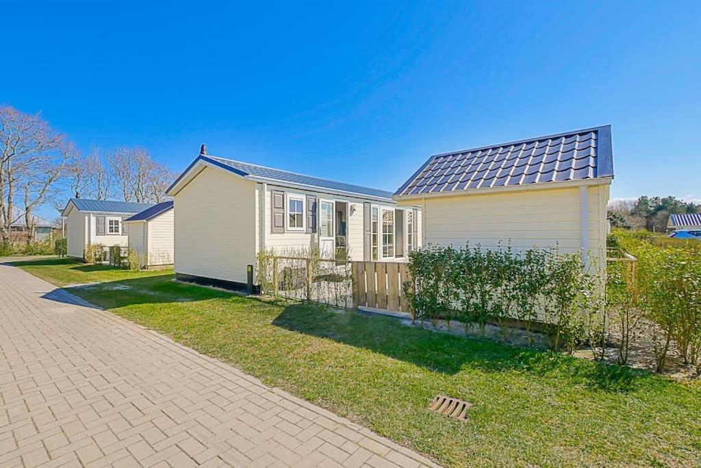 卡兰茨奥赫Chalet Luttikduin 21, aan het strand met ruime tuin! - Callantsoog的一座白色的房子,上面装有太阳能电池板