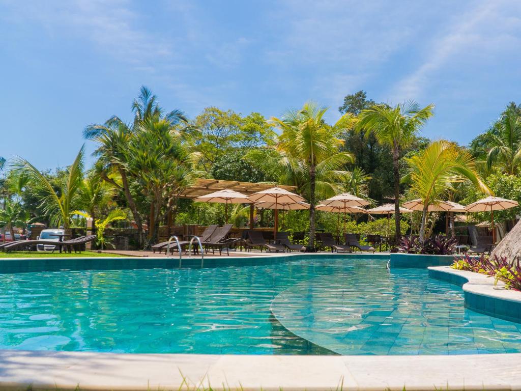 伊利亚贝拉Velas do Engenho的一座棕榈树和遮阳伞的游泳池