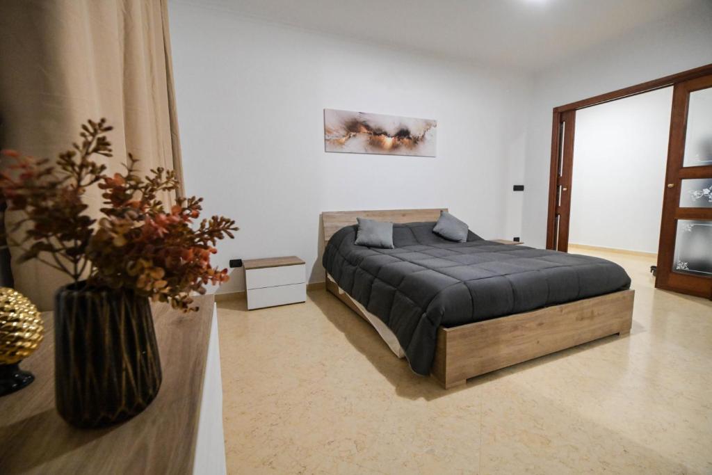 巴列塔Casa di Serena的一间卧室,配有一张床和花瓶