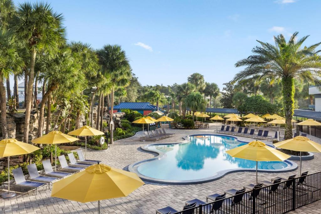 奥兰多Delta Hotels by Marriott Orlando Celebration的一张带有黄色遮阳伞的度假村游泳池的图片