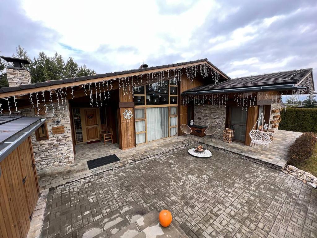 拉兹洛格Villa - VALL DI VALL in Pirin Golf & Country Club的房屋设有带桌子的石头天井