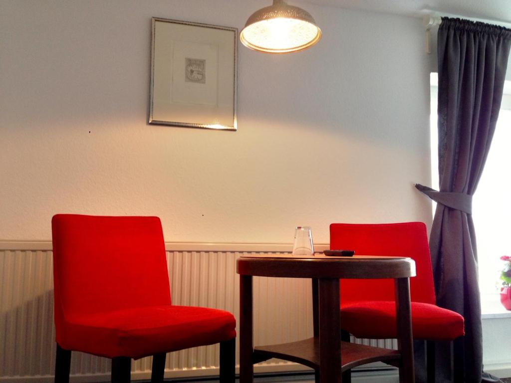 Freiroda莱比锡机场旅馆的两个红色的椅子和一张桌子