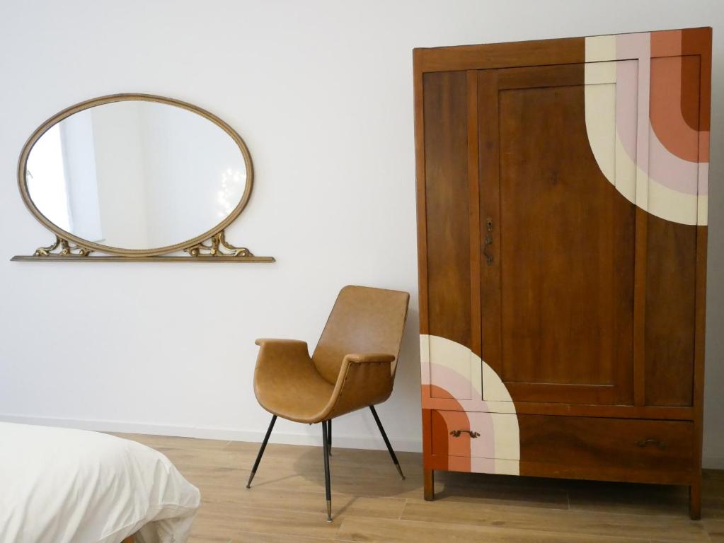 里米尼Anita Bnb Rimini的卧室配有镜子和椅子,位于门边