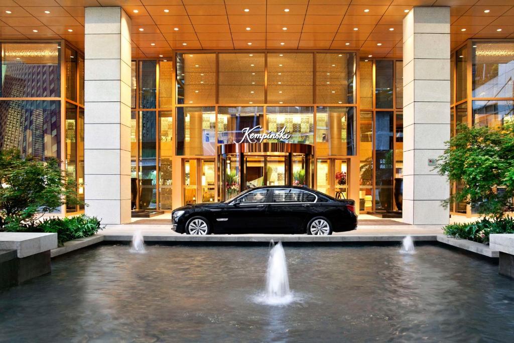重庆重庆凯宾斯基酒店的停在一座带喷泉的建筑前面的汽车