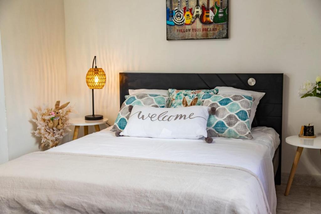 伊瓦格Coliving7 Aparta Hotel & Habitaciones的一间卧室配有一张带迎宾枕头的床