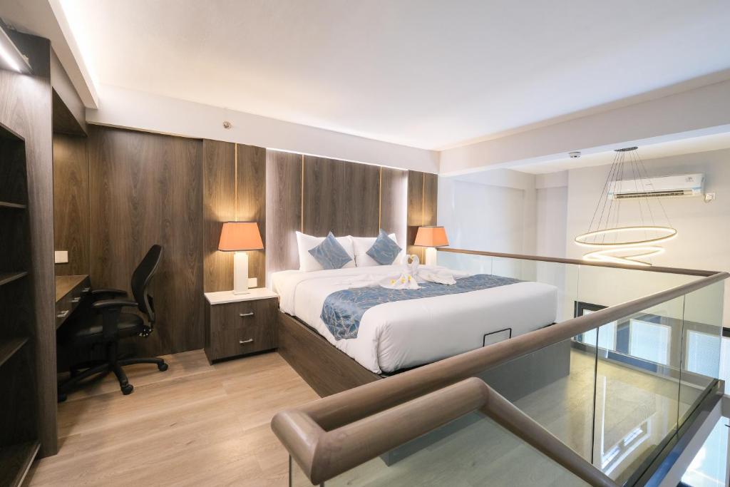 坎古Aster Apartment Bali的一间卧室设有一张床和一张书桌,铺有玻璃地板。