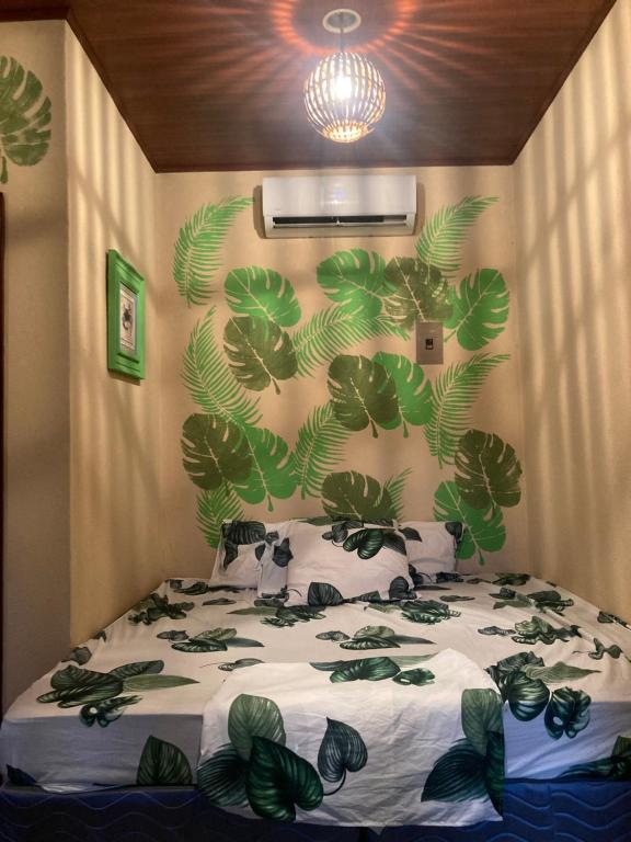 El ViejoJava Jungle的卧室配有一张挂着绿叶的墙壁床。