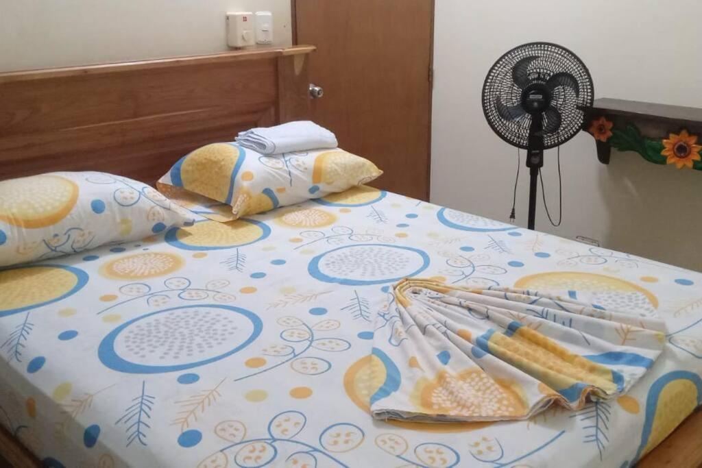 多拉代尔Casa en Doradal - Antioquia的一张带床罩的床,上面装有风扇