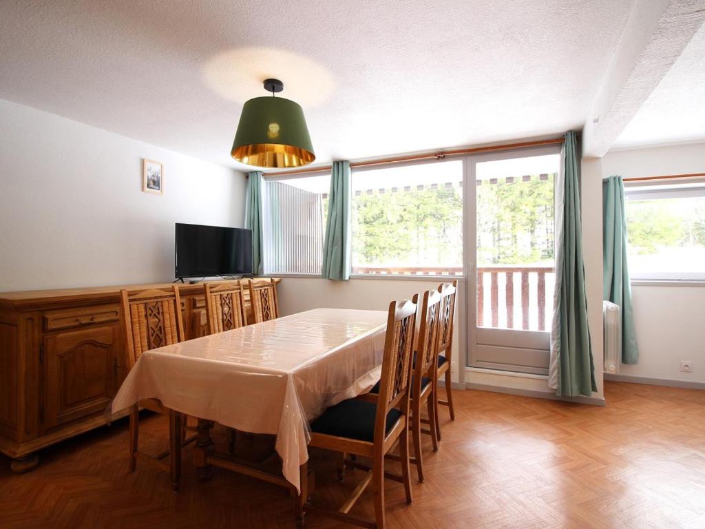 勒蒙多尔Charmant F2 bis au Mont-Dore avec balcon, au pied des pistes, 6 pers, parking, ascenseur - FR-1-415-150的一间带桌椅和窗户的用餐室