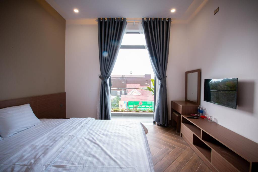 Kon PlongKhách sạn Mimosa的一间卧室设有一张床和一个大窗户