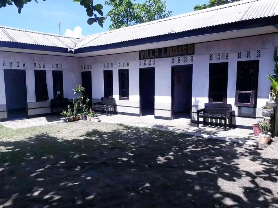 CikadalPenginapan & Homestay Geopark Ciletuh的一座古老的白色建筑,上面标有读酒店房子的标志