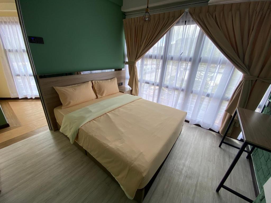 丹那拉打Clock Inn Backpackers Hostel的一间卧室设有一张带绿色墙壁和窗户的床。