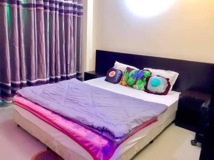 KelātaliWorld Beach Resort的一间卧室配有一张带紫色床单和枕头的床。