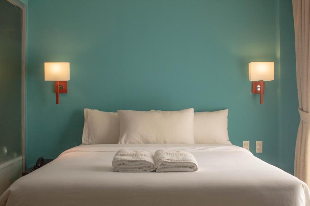 安吉利斯瓦伦蒂诺斯酒店的床上的两条毛巾,墙上是蓝色的