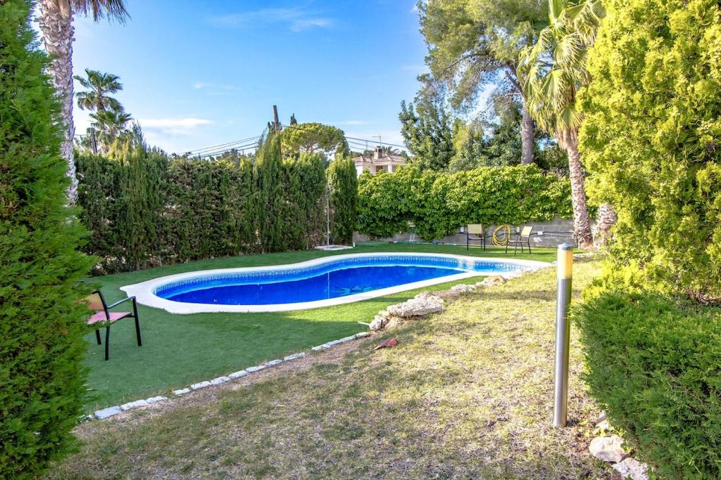 库尼特Catalunya Casas Costa Dorada Lair in Cunit, 2 km from Med Sea!的一座树木繁茂的庭院内的游泳池