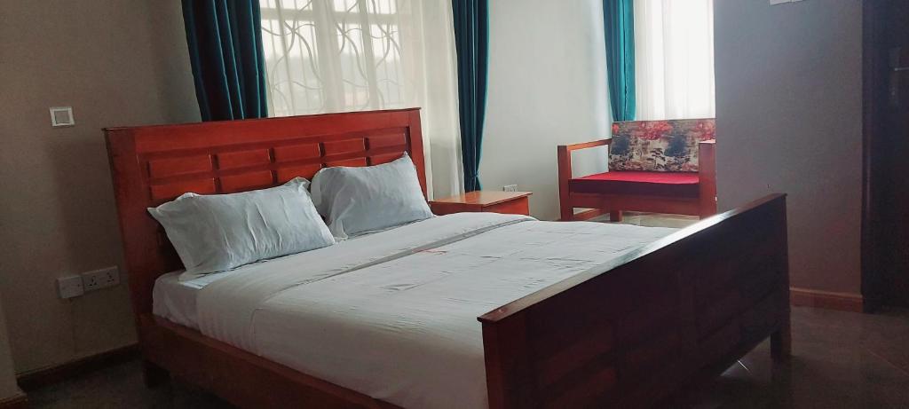 恩德培SEED HOTEL的一间卧室配有一张大床和一张红色椅子
