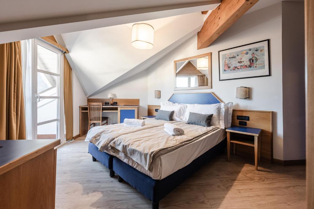 迪马罗Hotel garni Meledrio的一间卧室配有一张大床和蓝色床头板