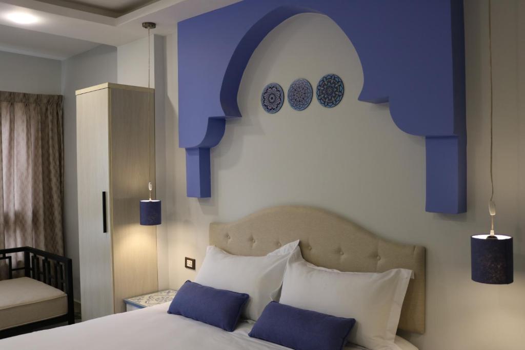 安曼Amman Trail Hotel & Studios的一间卧室配有一张带蓝色和白色枕头的床