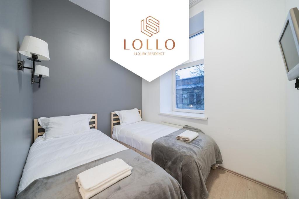 维尔纽斯Halės Self Check-in Guest House - Lollo Luxury的一张带阅读罗拉标志的房间里两张床铺