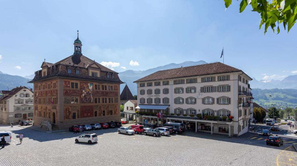 施维茨Wysses Rössli Swiss Quality Hotel的一群停车在停车场的汽车建筑