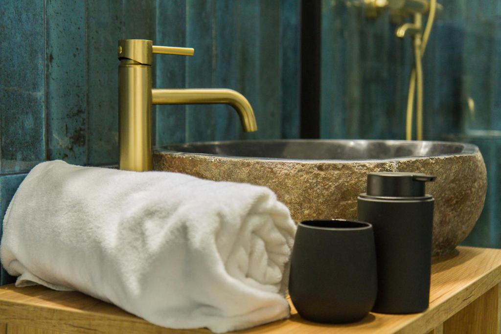 莱斯科Apartamenty Parkowa 9的浴室设有水槽、毛巾和1瓶肥皂。