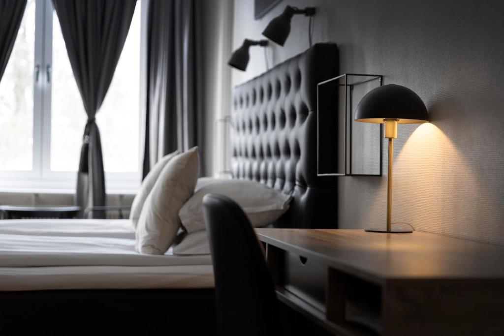 舍夫德约尔酒店的一间卧室配有一张床和一张带台灯的书桌