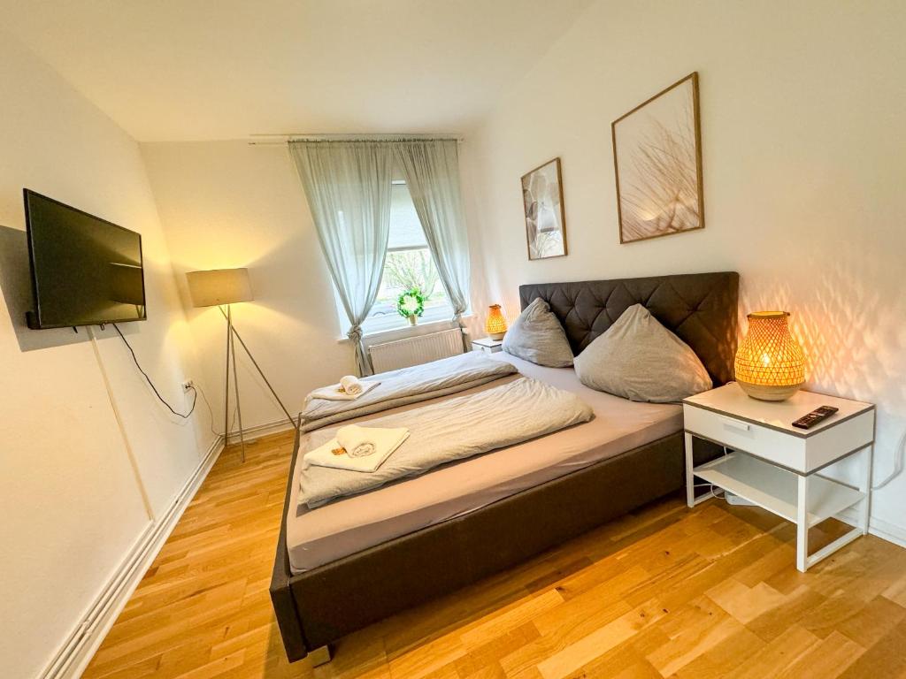 汉诺威Wohnung für 3 Gäste mit kostenlosen Parkplätzen nah am Maschsee的一间卧室配有一张带书桌的床和窗户。