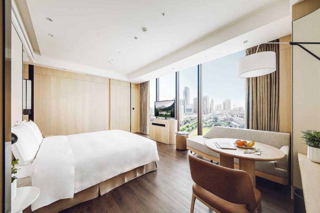 台北杰仕堡有氧酒店的酒店客房设有一张大床和一张桌子。