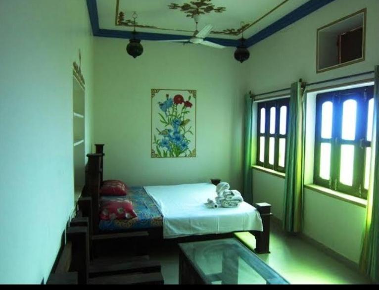 布什格尔Pushkar Guest House的一间绿灯客房内的一张床卧室