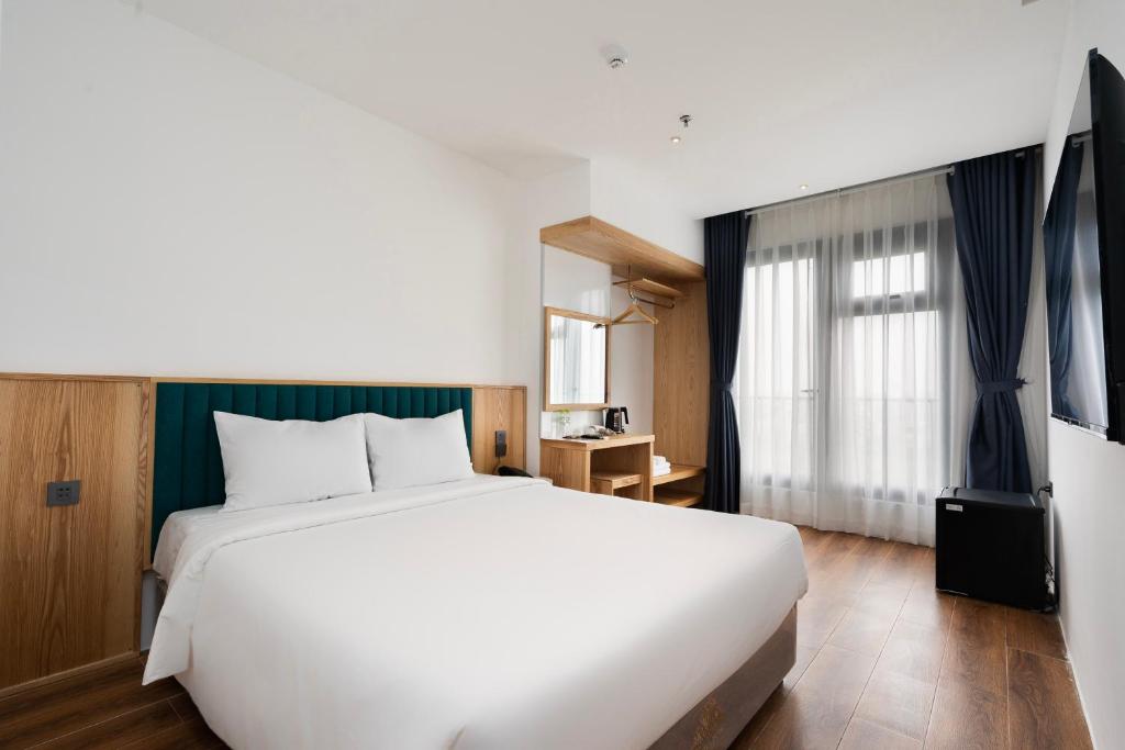 胡志明市Haven Hut Riverside Hotel的卧室设有一张白色大床和一扇窗户。