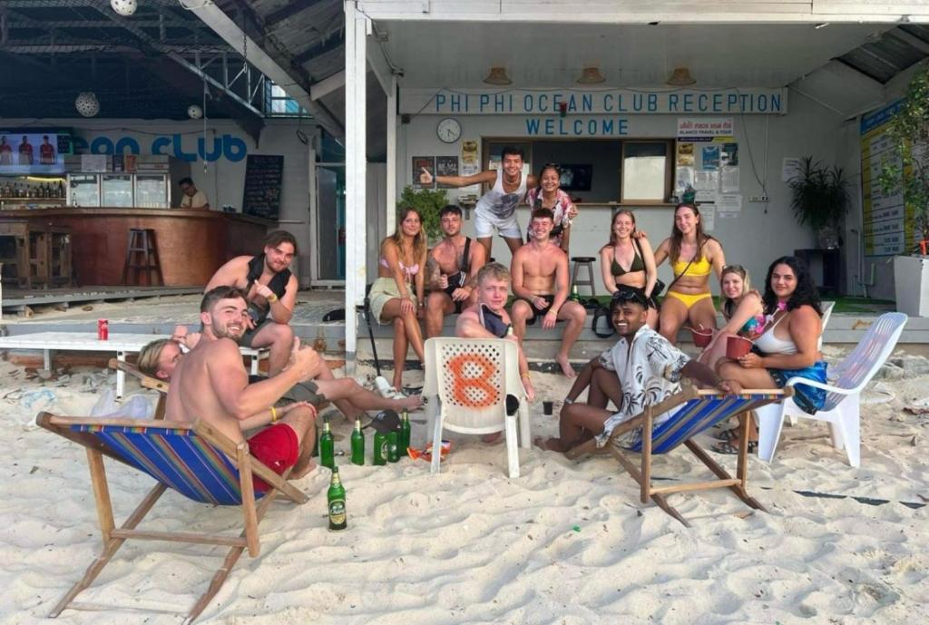 皮皮岛Phi Phi Ocean Club的一群人坐在沙滩上的椅子上