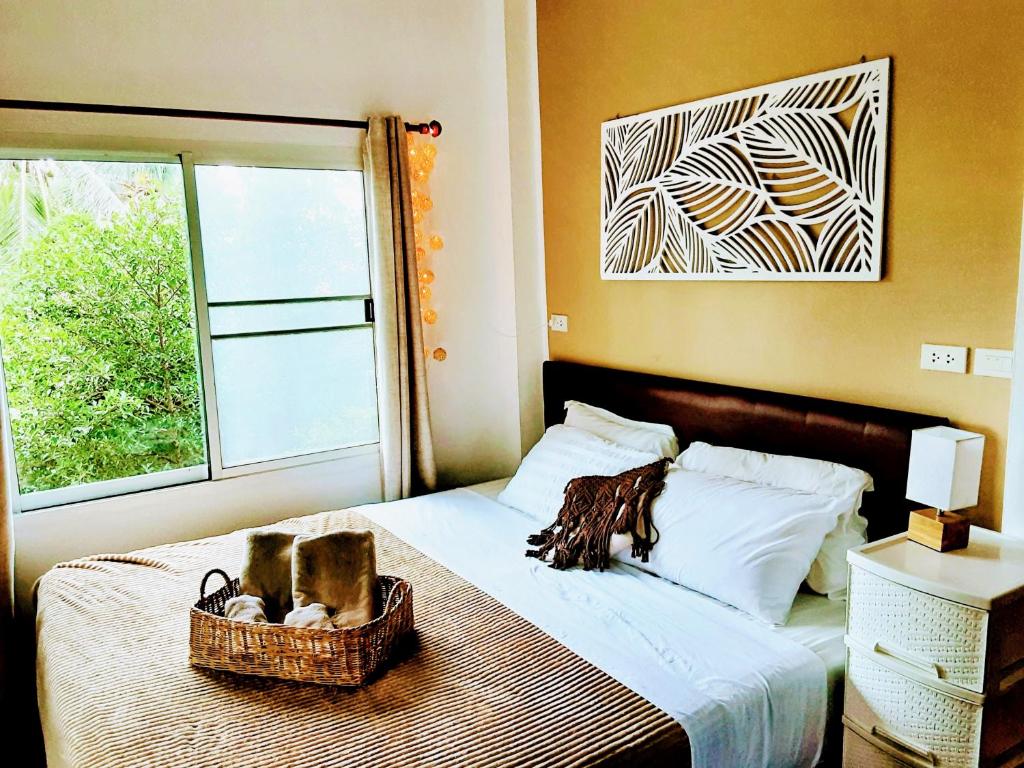 西塔努Mangrove beach house Sri Thanu的一间卧室配有一张带两个篮子的床和窗户。