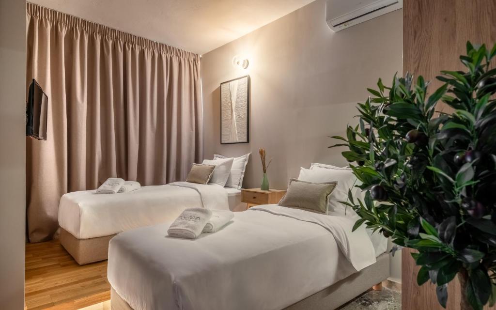 雅典Numa Suites & Lofts Athens的酒店客房设有两张床和盆栽植物