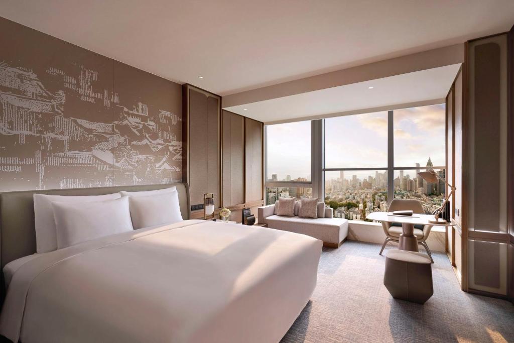 南京南京凯宾斯基酒店的卧室设有一张白色大床和大窗户