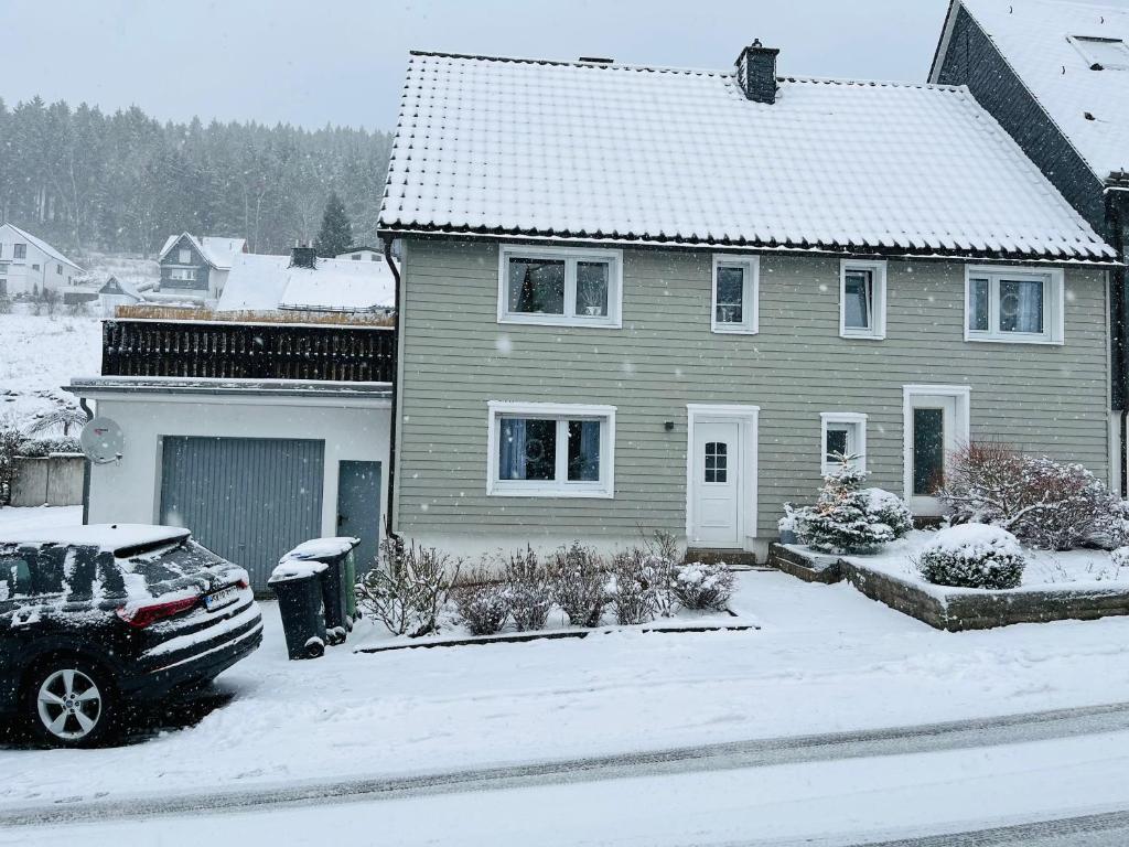 温特贝格Ferienhaus Sauerland - Traum的一座房子,里面的汽车停在一个雪地覆盖的院子内
