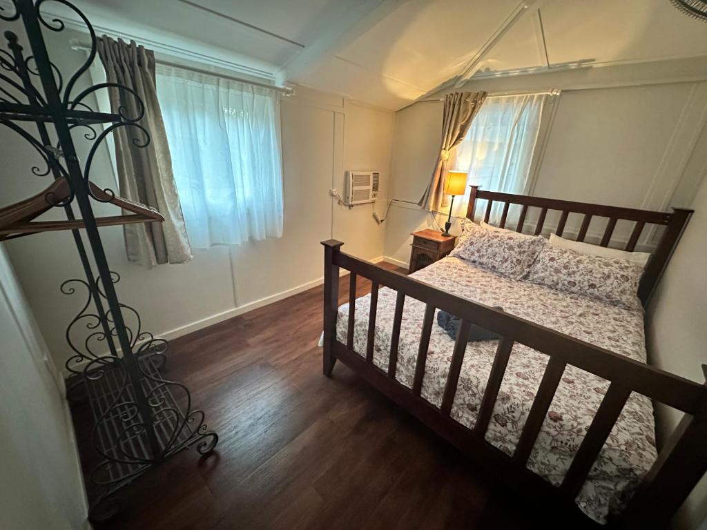 飞鱼湾Divers Villa的一间卧室配有一张铺有木地板的床和窗户。