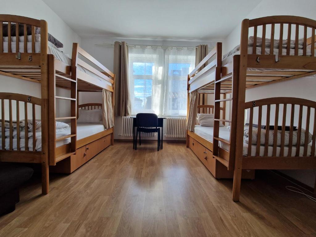雅西安德烈旅舍的带4张双层床和椅子的客房