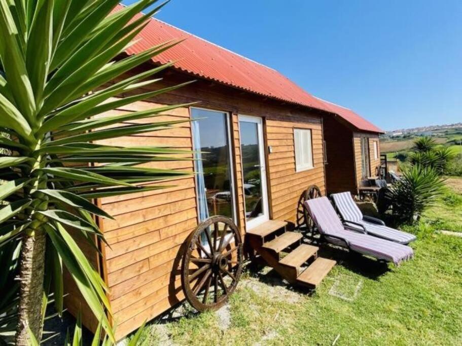 劳林哈Da Silva Surfcamp, Tiny House Luna的小木屋配有长凳和椅子