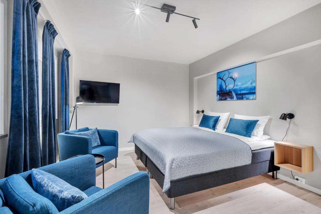 特罗姆瑟Bispegata 5 - Studio Apartment hotel的酒店客房,配有床和蓝色的沙发