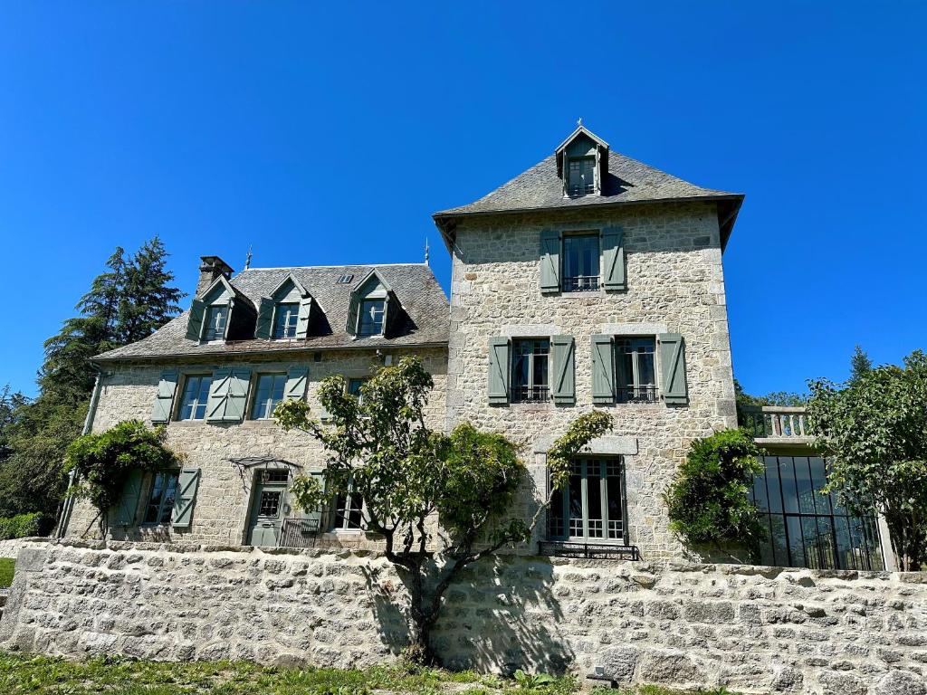 Saint-AngelLe Manoir du Rigouneix au coeur de la nature, calme-sauna-dîner maison的一座古老的石头建筑,上面有一座塔