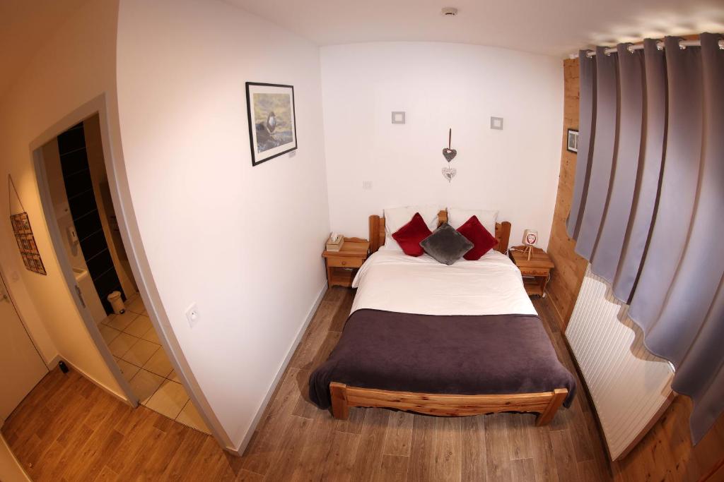 穆特Le Chalet de la Source的小卧室配有红色枕头的床