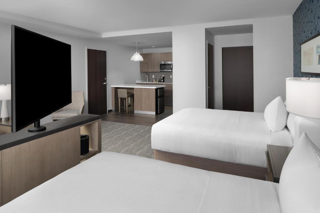 兰辛Hyatt House Lansing-University Area的配有一张床和一台平面电视的酒店客房