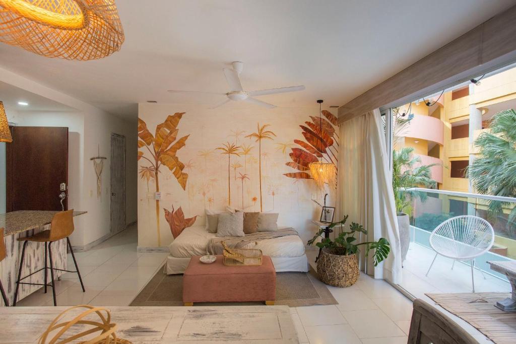 卡塔赫纳Condominio frente al mar con acceso directo a la playa Morros 922的客厅配有沙发,墙上种植了棕榈树。