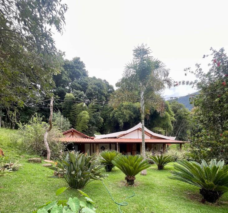 阿尤鲁奥卡Casa Portal Sagrado Matutu- Aiuruoca MG的树木林立的田野中的房子