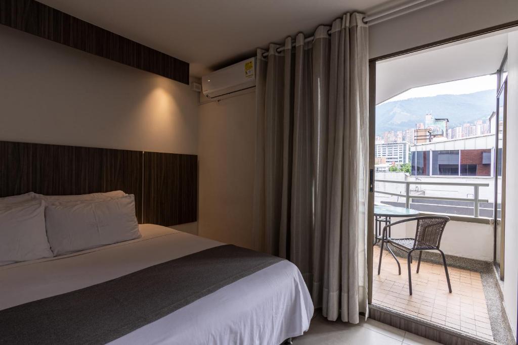 麦德林Hotel Torre Poblado的酒店客房设有一张床和一个阳台。
