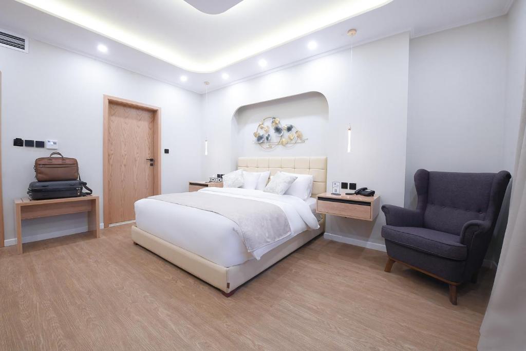 开罗Arabella Premium Residence - New Cairo的白色卧室配有床和椅子