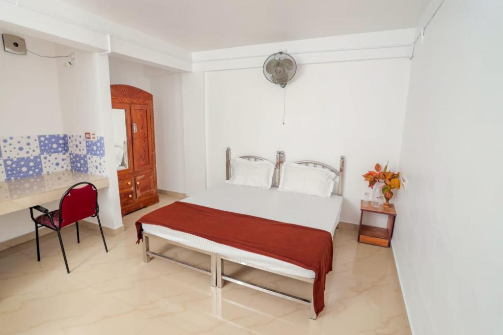蒙纳EL LORA RESlDENCY的一间卧室配有一张床和一张红色椅子