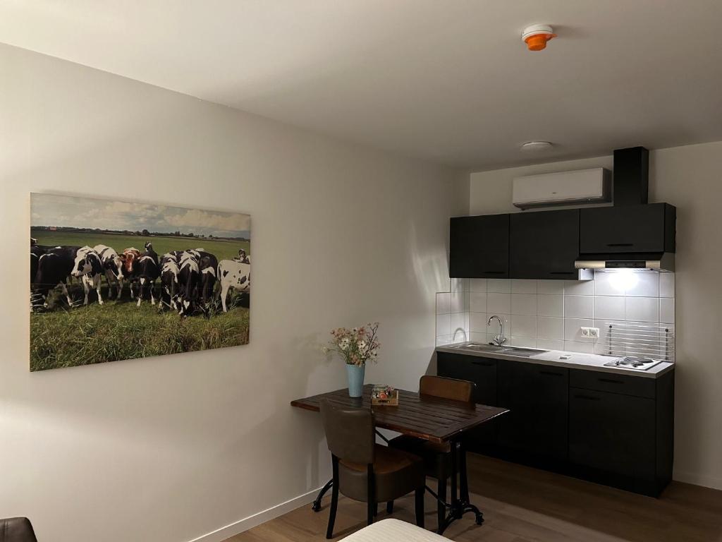 NijeveenHotel Nijeveen的厨房里放着一幅牛群的画作
