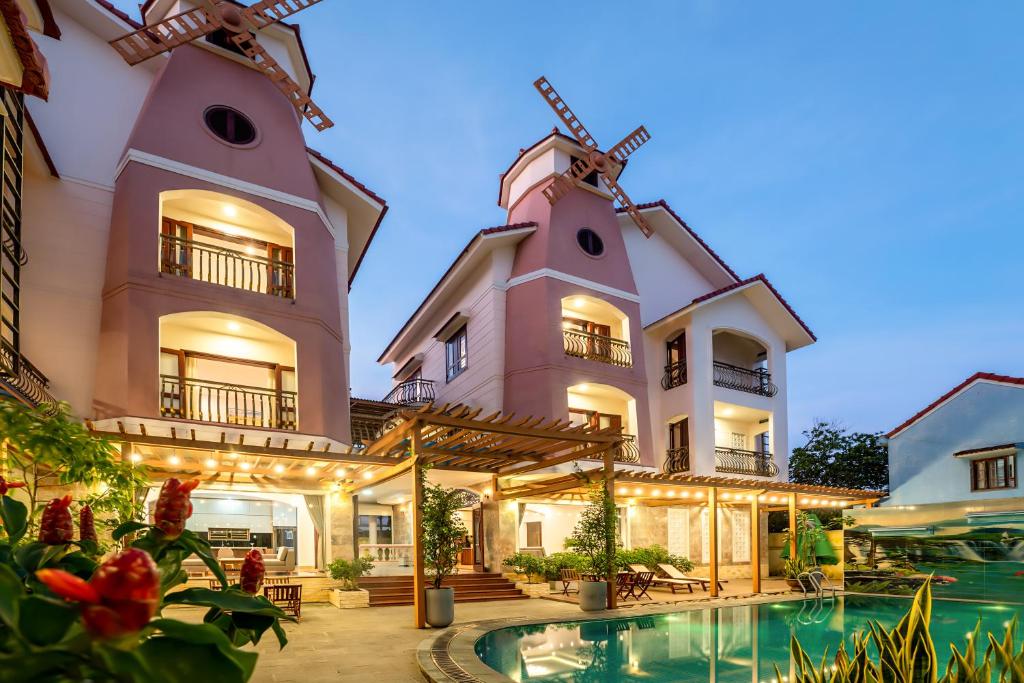 会安Ong Tam Villa Hoi An的一座带游泳池和风车的房子