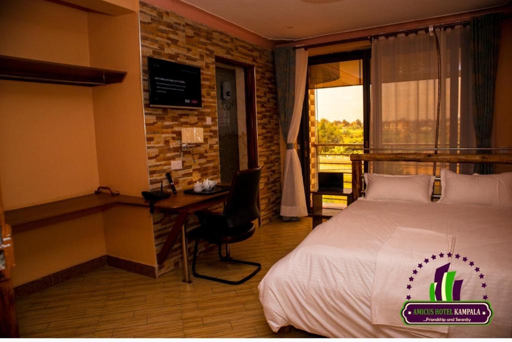 KirekaAmicus Hotel Kampala的配有一张床、一张书桌和一扇窗户的酒店客房
